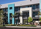 Thumbnail 44 of 116 - A modern building with a blue and white facade and a black metal staircase.