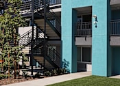 Thumbnail 18 of 116 - A modern building with a blue and white facade and a staircase leading to the second floor.