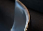 Thumbnail 33 of 116 - A black chair with a white seat and a brown stitched back.