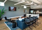 Thumbnail 19 of 116 - A modern waiting room with a large couch, chairs, and a flat screen TV mounted on the wall.