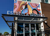 Thumbnail 6 of 116 - The entrance to Estrella Springs with a colorful mural above it.