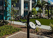 Thumbnail 11 of 116 - A black and white outdoor gym equipment set in front of a building.