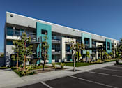 Thumbnail 13 of 116 - A modern building with a parking lot in front.