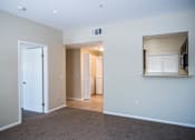 Thumbnail 27 of 36 - A room with a white door, a window with blinds, and a wall-mounted TV.