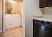 Thumbnail 35 of 36 - A black dishwasher is in a kitchen next to a wall.