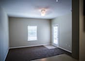 Thumbnail 24 of 36 - A room with a carpeted floor and a door leading to another room.
