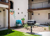 Thumbnail 16 of 36 - A patio with a grill and a wall mural of a blue cow.