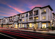 Thumbnail 100 of 114 - A modern apartment building with a long exposure street in front.