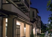 Thumbnail 114 of 114 - A row of houses with lit up windows and balconies.