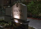 Thumbnail 113 of 114 - A sign that says Heroes Landing stands in front of a building.