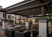 Thumbnail 102 of 114 - A patio with a table and chairs under a roof.