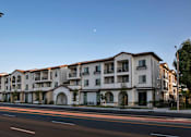 Thumbnail 108 of 114 - A large apartment building with a clear blue sky above it.