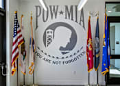 Thumbnail 91 of 114 - A wall with a sign that says "POW-MIA" and flags on either side.