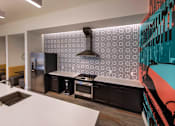 Thumbnail 90 of 114 - A modern kitchen with a white countertop and black appliances.