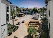 Thumbnail 75 of 114 - A courtyard surrounded by buildings with a basketball court and a tree.