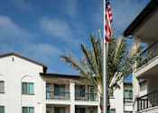 Thumbnail 76 of 114 - A white building with a flag on a pole in front.