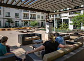 Thumbnail 71 of 114 - People are sitting on the benches under the wooden roof.