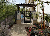 Thumbnail 62 of 114 - A gate with a black metal railing and a wooden pergola above it.