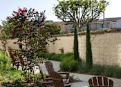 Thumbnail 74 of 114 - Three wooden chairs are placed on a patio.