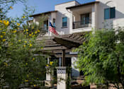 Thumbnail 47 of 114 - A building with a flag on the balcony is surrounded by greenery.
