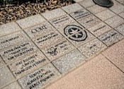 Thumbnail 43 of 114 - A brick with a star and a bird on it is part of a memorial.