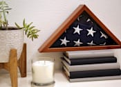 Thumbnail 27 of 114 - A white candle sits in front of a small American flag.
