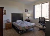 Thumbnail 10 of 114 - A bedroom with a bed, chair, and nightstand.