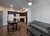 Thumbnail 9 of 114 - A modern kitchen with dark wood floors and white appliances.