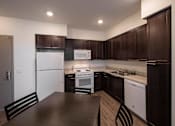 Thumbnail 11 of 114 - A kitchen with dark brown cabinets and white appliances.