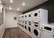 Thumbnail 12 of 114 - A row of white washing machines in a laundromat.