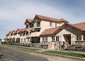 Thumbnail 1 of 2 - A row of houses with brown roofs and black fences.