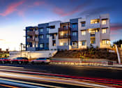 Thumbnail 22 of 103 - A modern building with a car parked in front of it.