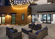 Thumbnail 14 of 103 - A patio with wicker furniture and string lights.