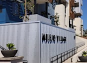 Thumbnail 68 of 103 - A modern building with the name "Mileio Village" on its facade.