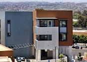 Thumbnail 56 of 103 - A modern building with a view of the city in the background.
