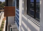 Thumbnail 67 of 103 - A modern house with a balcony and a wooden railing.