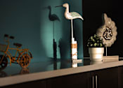 Thumbnail 41 of 103 - A white bird statue stands on a shelf next to a yellow bicycle.