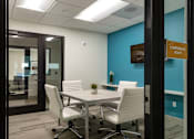 Thumbnail 48 of 103 - A conference room with a table and chairs.