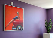 Thumbnail 44 of 103 - A woman is sitting on a red car in a painting.
