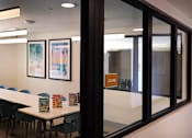 Thumbnail 49 of 103 - A conference room with a long table and chairs, a framed picture on the wall, and a sign that says "LOUNGE".