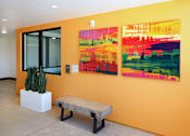 Thumbnail 13 of 103 - A bright orange wall with two paintings and a bench.