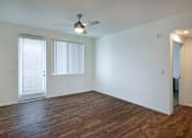 Thumbnail 16 of 103 - A room with a ceiling fan and wooden flooring.