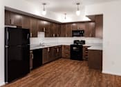 Thumbnail 18 of 103 - A kitchen with wooden floors and dark brown cabinets.