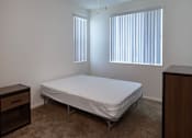Thumbnail 103 of 103 - A bedroom with a bed, dresser, and ceiling fan.