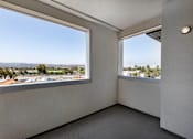 Thumbnail 83 of 103 - A room with two windows overlooking a parking lot.
