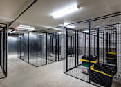 Thumbnail 80 of 103 - A room with multiple black cages and a concrete floor.