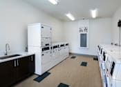 Thumbnail 87 of 103 - A laundry room with washers and dryers.