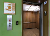 Thumbnail 85 of 103 - An elevator with a green wall and a sign on it.