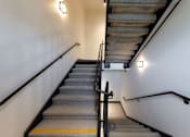 Thumbnail 88 of 103 - A staircase with a metal handrail and wooden steps.