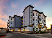 Thumbnail 75 of 94 - A modern multi-story residential building with a mix of grey and white exterior.
